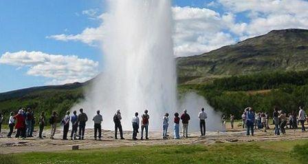 De geiser Stokkur in IJsland trekt veel toeristen die in IJsland op vakantie zijn
